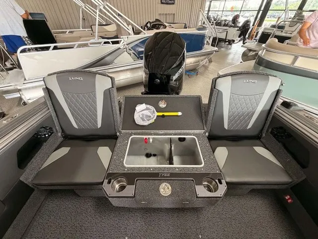 Slide: The Image of The image shows the interior of a 2027 Lund 1875 Tyee SS boat with two seats and a sink. - 14