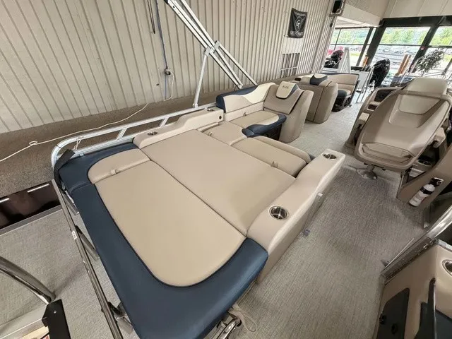 Slide: The Image of The image shows the interior of a 2027 Avalon LSZ 2385 VRB. There are beige and blue upholstered seats with cup holders in a spacious area. - 13