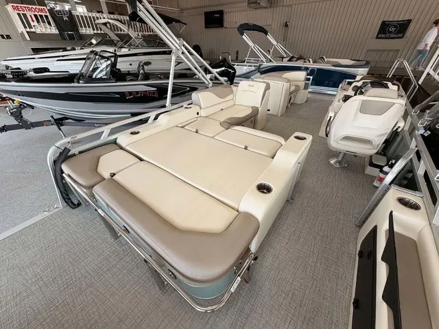 Slide: The Image of The image shows a modern pontoon boat with beige upholstery in a showroom. - 13