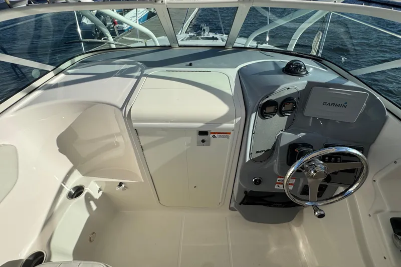 Slide: The Image of 2014 Wellcraft 252 Coastal boat cockpit with Garmin navigation system and steering wheel. - 13