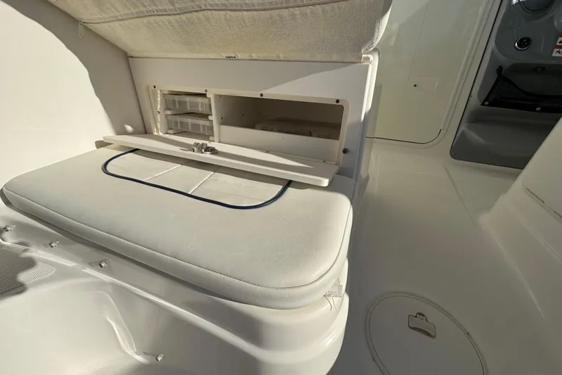 Slide: The Image of 2014 Wellcraft 252 Coastal boat interior with storage compartment and cushioned seating. - 18