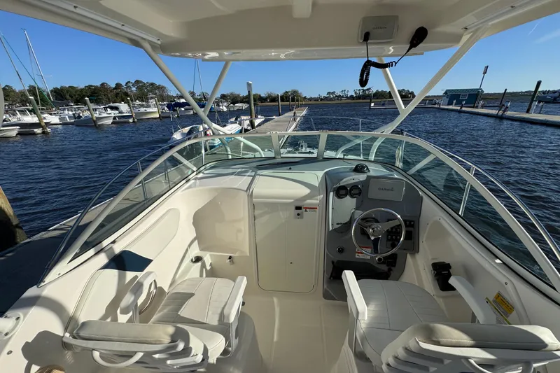Slide: The Image of 2014 Wellcraft 252 Coastal boat interior at marina, featuring helm and seating. - 11