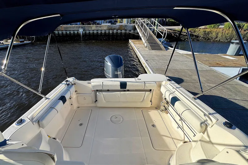 Slide: The Image of 2014 Wellcraft 252 Coastal boat interior with seating, docked by the water. - 21