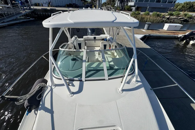 Slide: The Image of 2014 Wellcraft 252 Coastal boat docked at marina, featuring spacious deck and sleek design. - 9