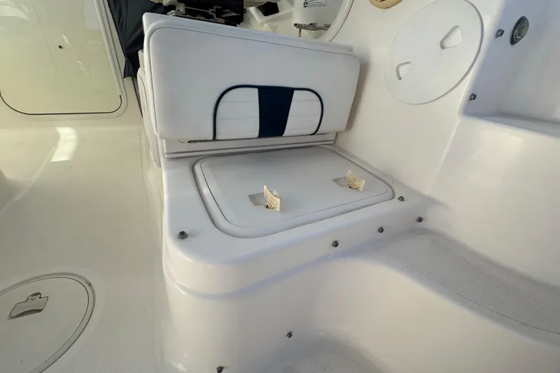 Slide: The Image of 2014 Wellcraft 252 Coastal boat interior with white seating and storage compartment. - 16