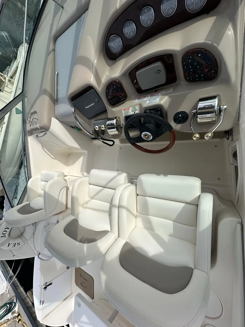 Slide: The Image of 2003 Sea Ray 340 Sundancer cockpit with white leather seats and control panel. - 25