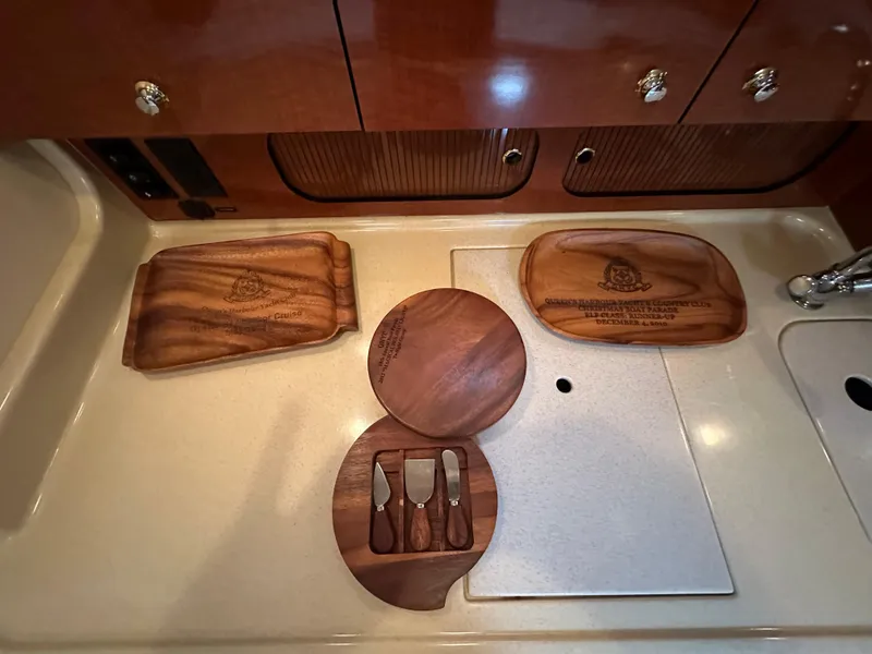 Slide: The Image of 2003 Sea Ray 340 Sundancer kitchen with wooden cutting boards and cheese set. - 48