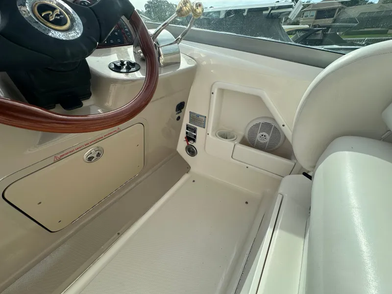 Slide: The Image of 2003 Sea Ray 340 Sundancer helm area with steering wheel and control panel. - 34