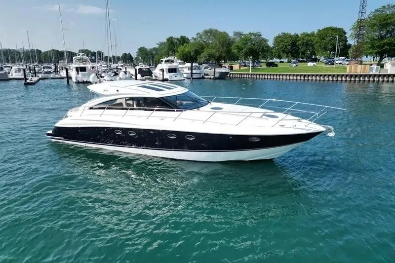 The Image of 2008 Princess V53 yacht cruising in a marina with clear blue water. - 1