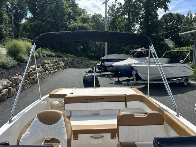 Slide: The Image of A 2022 Bayliner VR5 Bowrider OB with brown seats and a black Bimini top. - 14