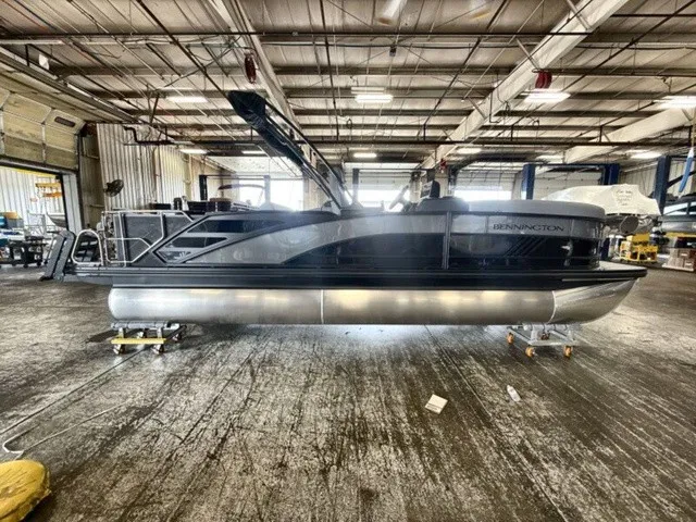 Slide: The Image of A 2027 Bennington M Fishing 22 MFC Tritoon sits on a trailer in a large warehouse. - 9