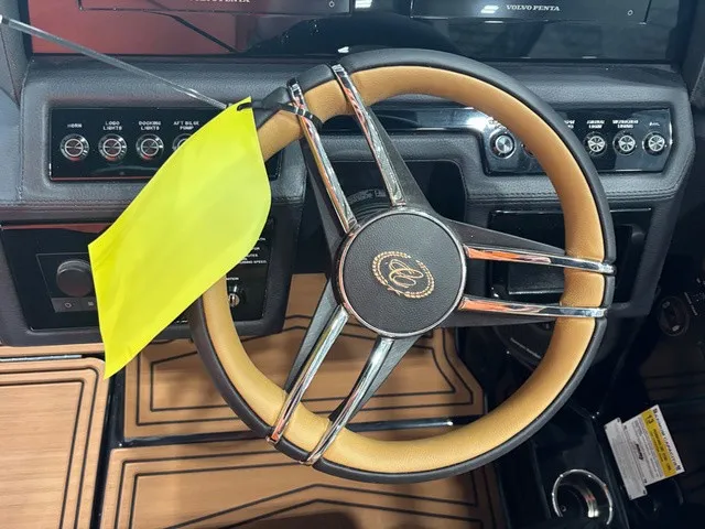 Slide: The Image of The image shows the steering wheel of a 2027 Cobalt R4 Surf boat with a yellow flag. - 13