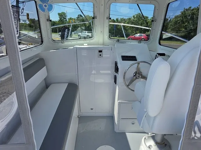 Slide: The Image of The image shows the cockpit of a Steiger Craft 21 Miami boat with white seating and a steering wheel. - 3