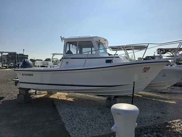 The Image of A 2027 Steiger Craft 21 Miami boat is on a gravel lot. It features an enclosed helm. - 1