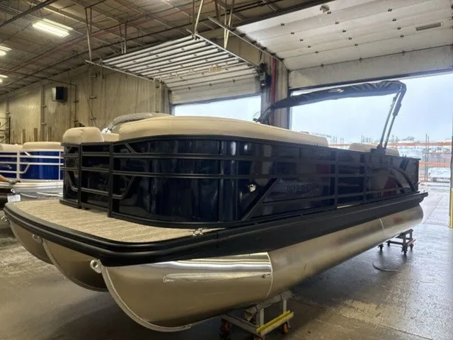 The Image of A 2027 Bennington S Fishing 22 SFC Tritoon is in a warehouse. It features a sleek design with a sturdy triple hull. - 1