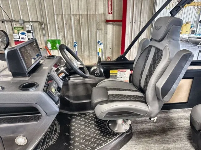 Slide: The Image of The image shows the helm of a 2027 Bennington M Fishing 22 MFC Tritoon with a cushioned captain's chair and modern dashboard. - 12