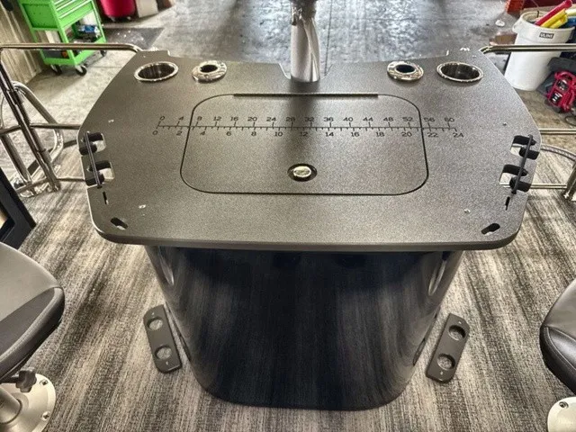 Slide: The Image of The image shows a black helm console with cup holders and a measurement scale on a boat. - 19