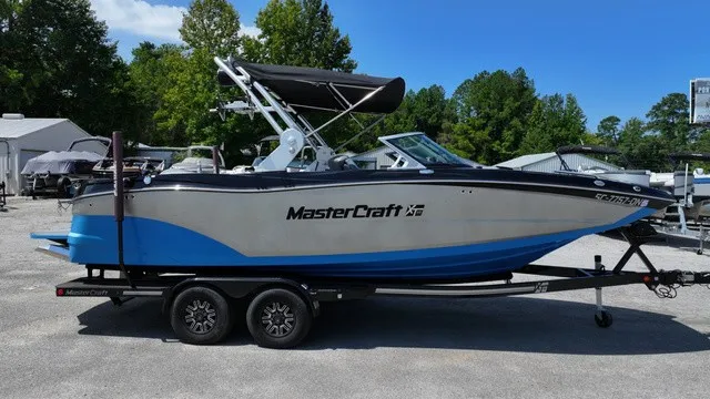 Slide: The Image of A 2019 MasterCraft XT22 boat on a trailer. It features a blue and white design. - 11