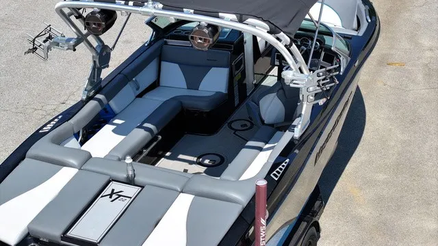 Slide: The Image of The image shows a 2019 MasterCraft XT22 boat with gray and black seating and a Bimini top. - 6