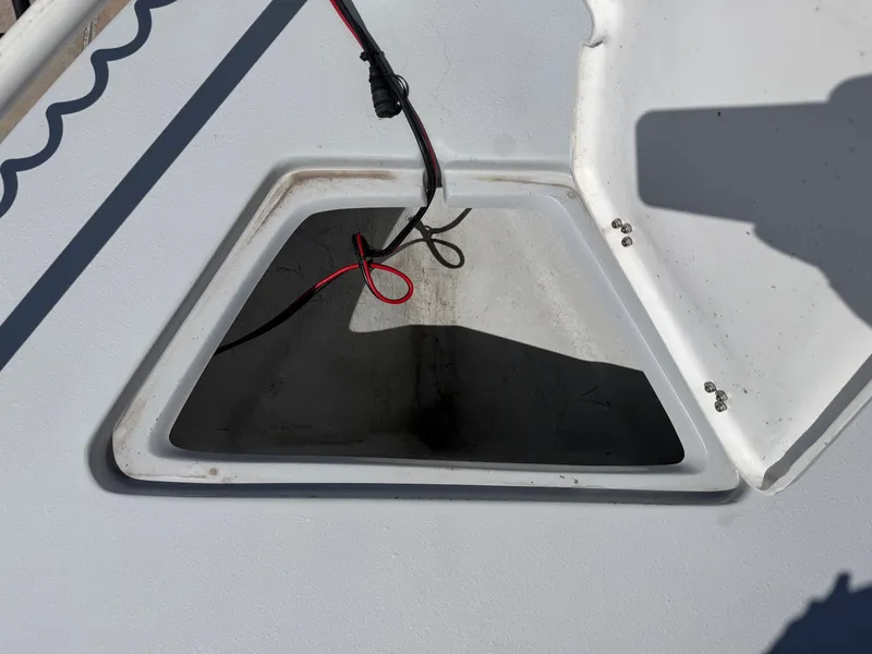Slide: The Image of An open storage compartment on a boat with visible wiring. - 14