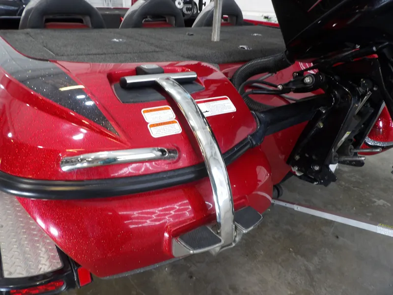 Slide: The Image of Red boat with a black motor, shiny finish, and stickers. It is indoors. - 19