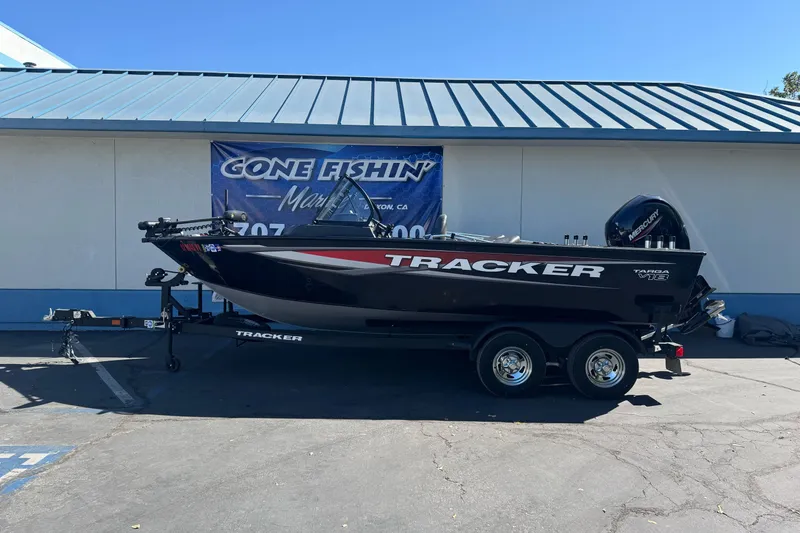 The Image of 2025 Tracker Targa V-18 Combo boat on trailer, parked outside a building. - 1