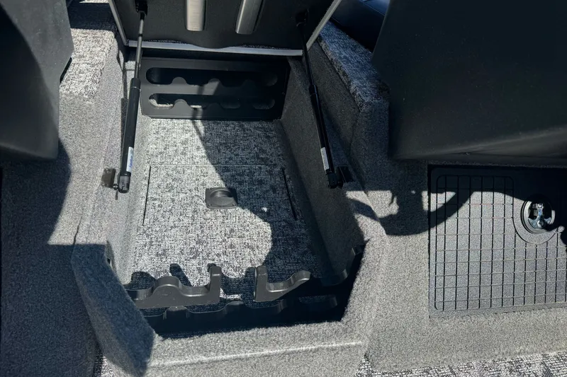 Slide: The Image of Interior storage compartment of 2025 Tracker Targa V-18 Combo boat, featuring carpeted flooring. - 19