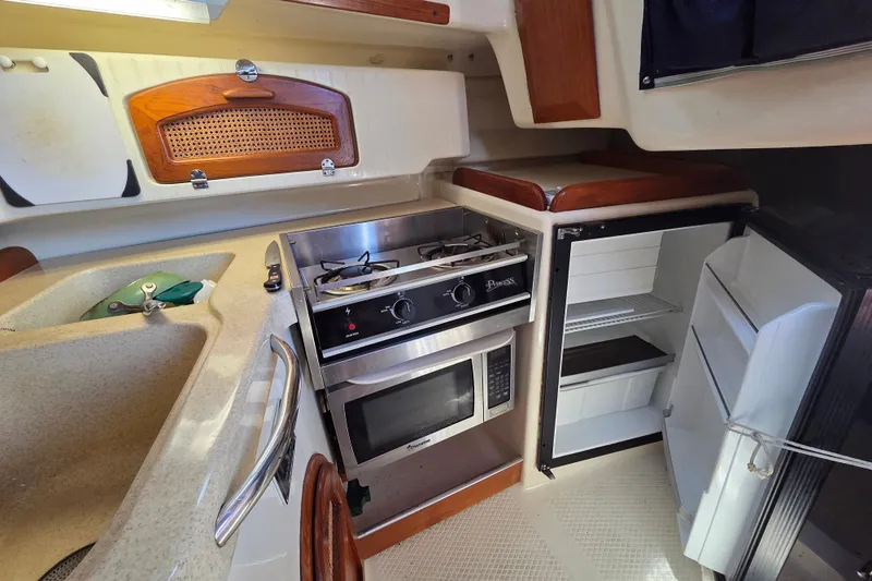 Slide: The Image of Compact kitchen in 2011 Hake Seaward 32RK boat with stove, microwave, and fridge. - 23