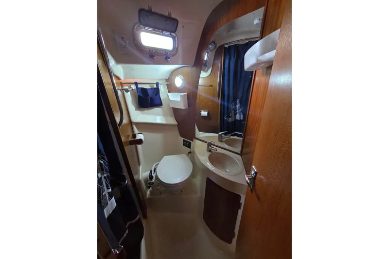 Slide: The Image of Compact bathroom in a 2011 Hake Seaward 32RK sailboat, featuring a toilet, sink, and porthole. - 30