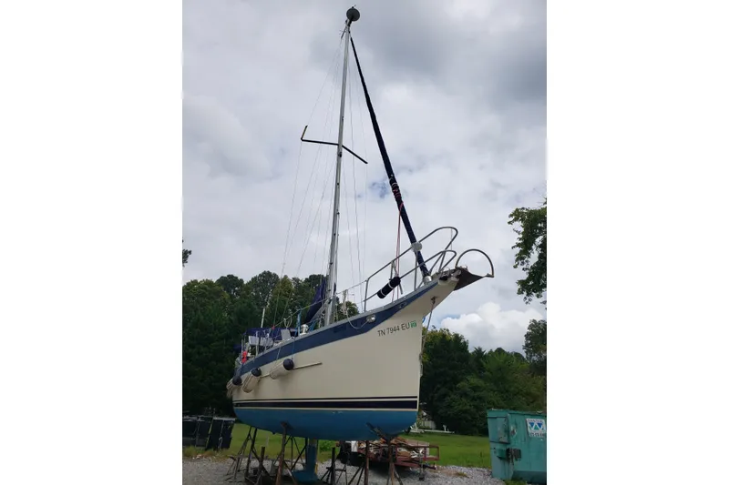 Slide: The Image of 2011 Hake Seaward 32RK sailboat on land, surrounded by trees and cloudy sky. - 48