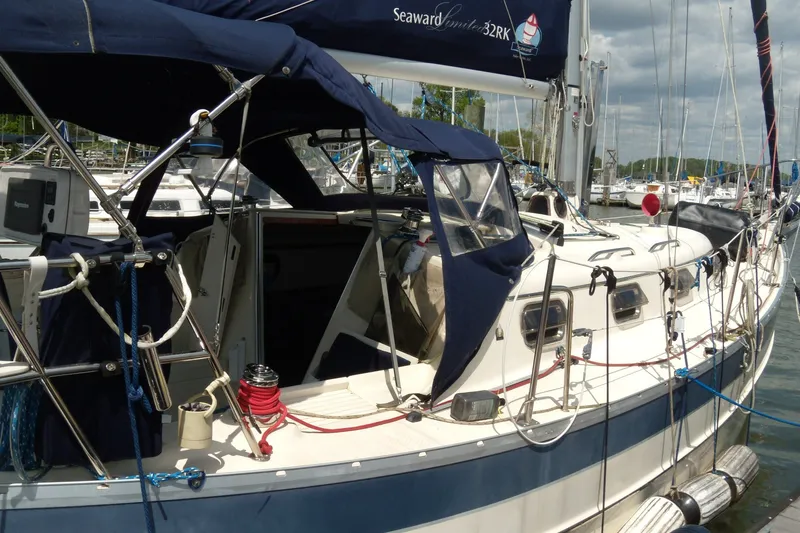 The Image of 2011 Hake Seaward 32RK sailboat docked at a marina, featuring blue canvas covers. - 1