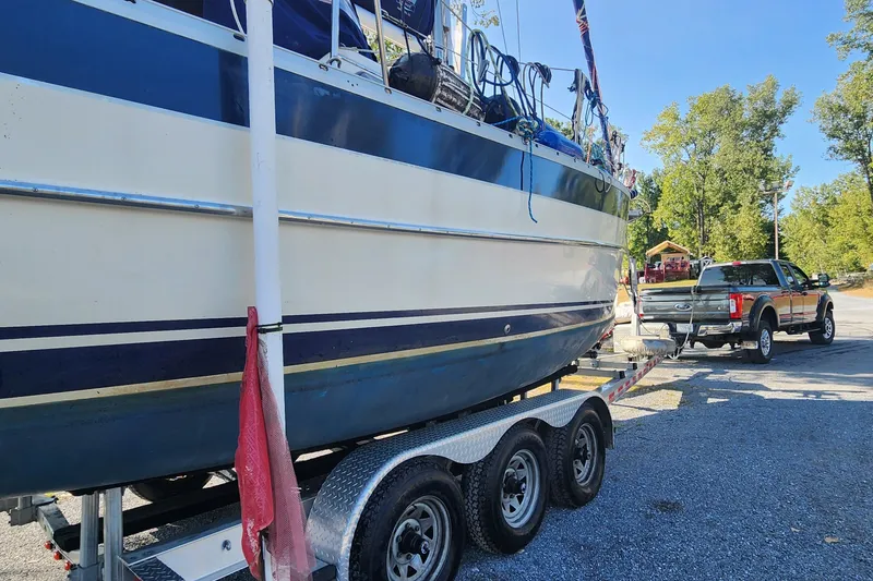 Slide: The Image of 2011 Hake Seaward 32RK sailboat on trailer, towed by a truck in a parking area. - 49