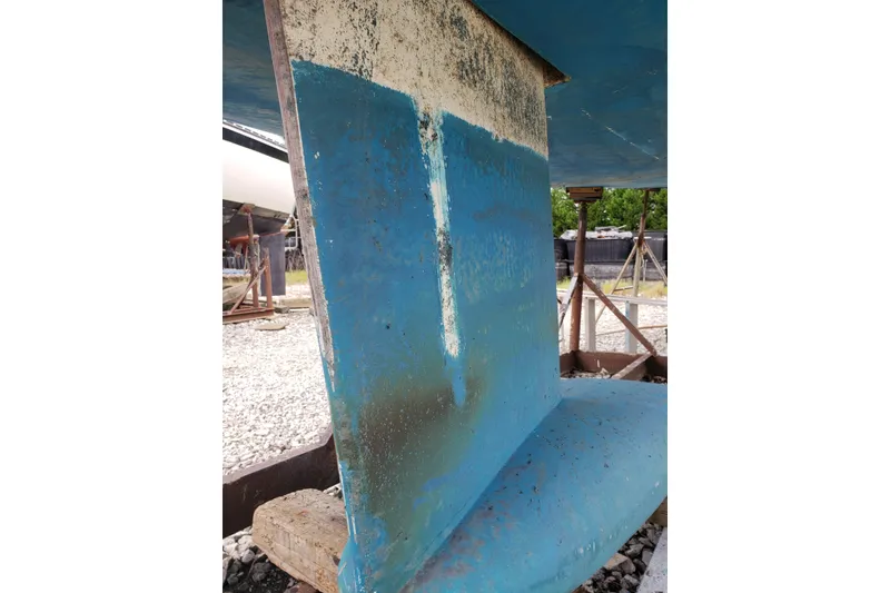 Slide: The Image of 2011 Hake Seaward 32RK sailboat keel in dry dock, showing blue paint and wear. - 55
