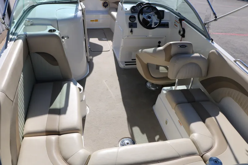 Slide: The Image of 2013 NauticStar 223DC Sport Deck interior with beige seating and steering console. - 18