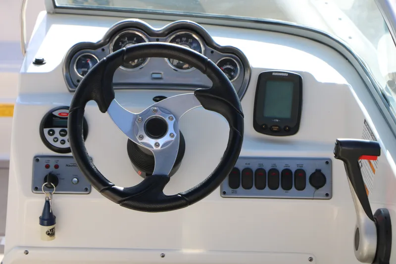 Slide: The Image of 2013 NauticStar 223DC Sport Deck dashboard with steering wheel and controls. - 21