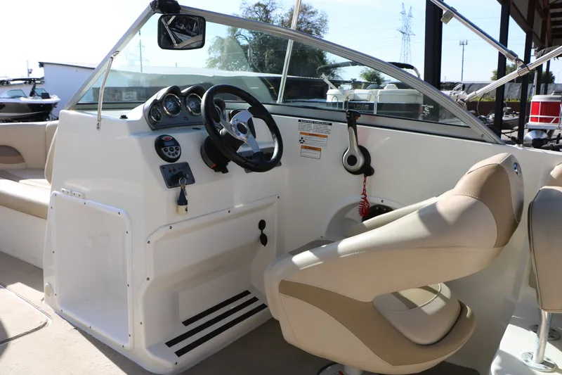 Slide: The Image of 2013 NauticStar 223DC Sport Deck boat interior with steering wheel and beige seating. - 35