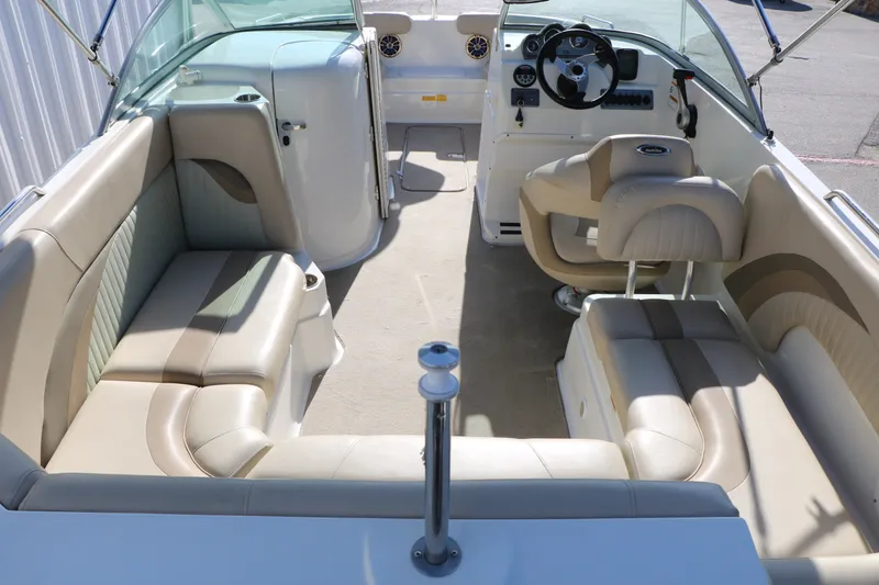 Slide: The Image of 2013 NauticStar 223DC Sport Deck interior with beige seating and steering console. - 19