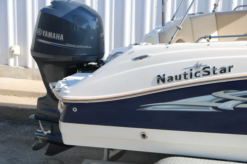 Slide: The Image of 2013 NauticStar 223DC Sport Deck with Yamaha outboard motor, parked near a building. - 15