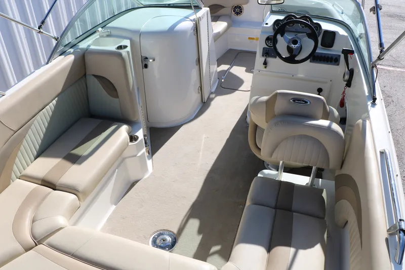 Slide: The Image of 2013 NauticStar 223DC Sport Deck interior with beige seating and steering console. - 22