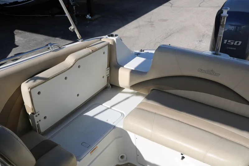 Slide: The Image of 2013 NauticStar 223DC Sport Deck interior with beige seating and Yamaha 150 engine. - 47