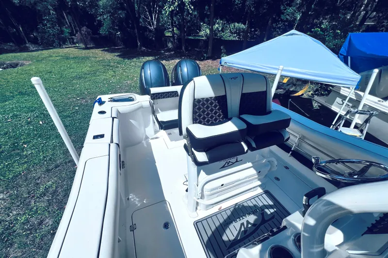 Slide: The Image of 2021 Tidewater 256 CC Adventure boat interior with dual seats and twin engines. - 14