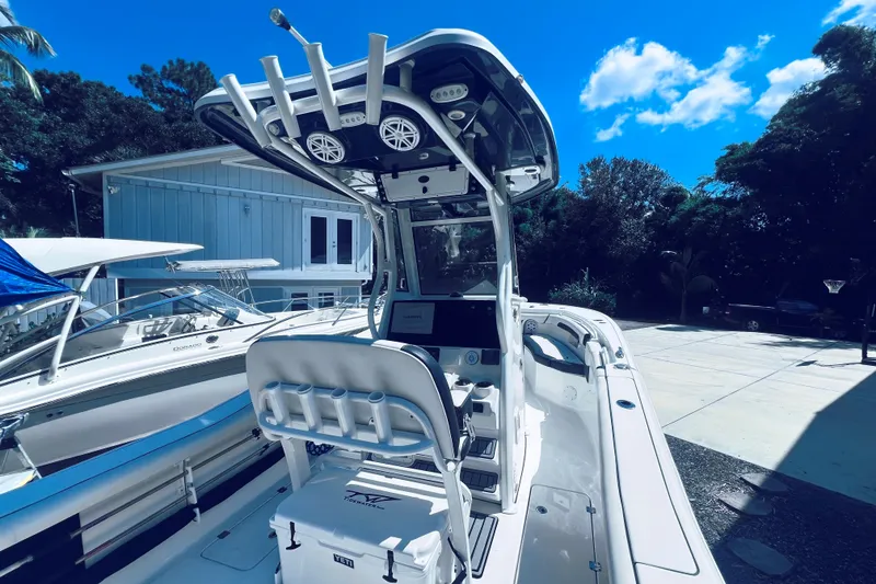 Slide: The Image of 2021 Tidewater 256 CC Adventure boat with modern console and seating, parked outdoors. - 13