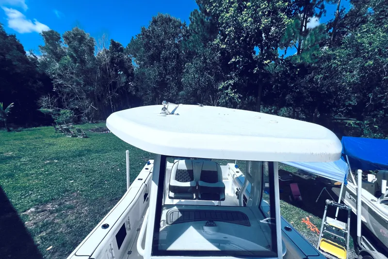 Slide: The Image of 2021 Tidewater 256 CC Adventure boat in a lush, green outdoor setting. - 22
