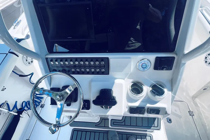 Slide: The Image of 2021 Tidewater 256 CC Adventure boat dashboard with steering wheel and control panel. - 27