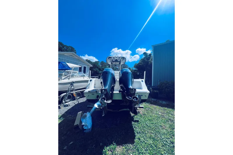 Slide: The Image of 2021 Tidewater 256 CC Adventure boat with dual engines in a sunny yard. - 7