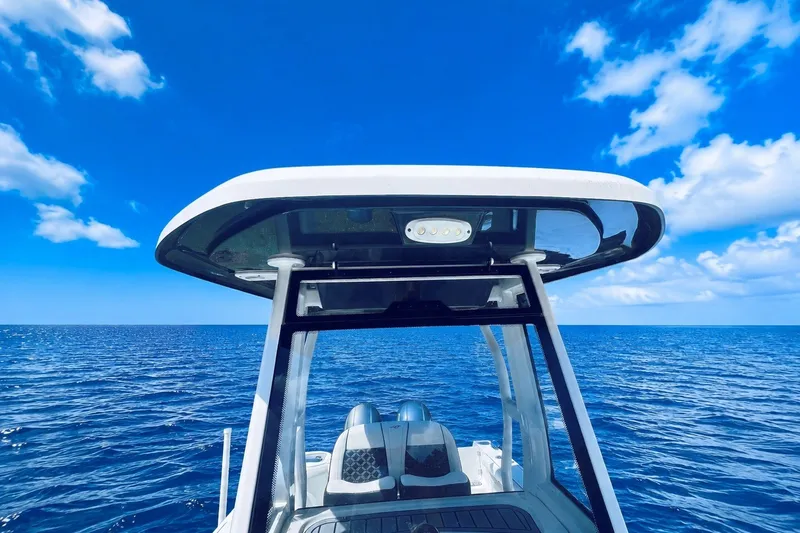 Slide: The Image of 2021 Tidewater 256 CC Adventure boat on open ocean under clear blue sky. - 5