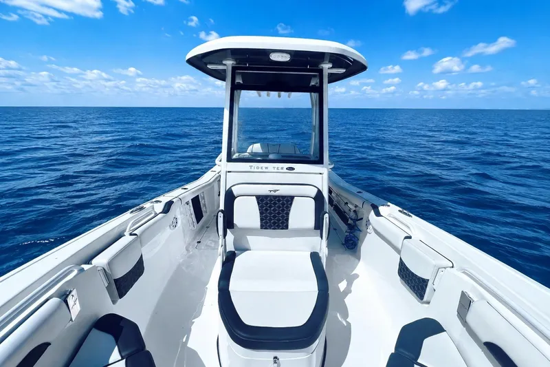 Slide: The Image of 2021 Tidewater 256 CC Adventure boat on open ocean under clear blue sky. - 4