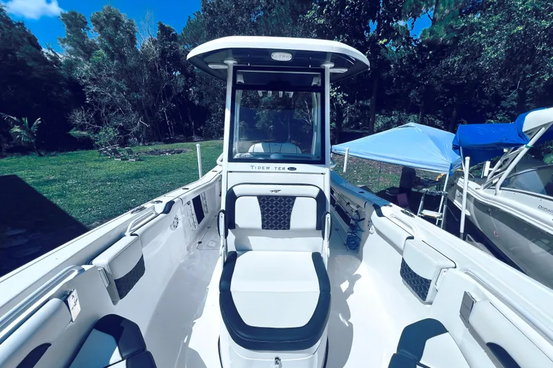 Slide: The Image of 2021 Tidewater 256 CC Adventure boat with seating, parked outdoors. - 17