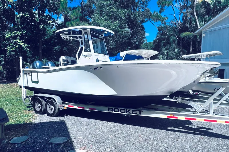Slide: The Image of 2021 Tidewater 256 CC Adventure boat on trailer, parked outdoors. - 32