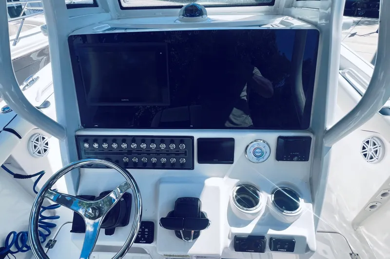 Slide: The Image of 2021 Tidewater 256 CC Adventure boat dashboard with steering wheel and control panel. - 28